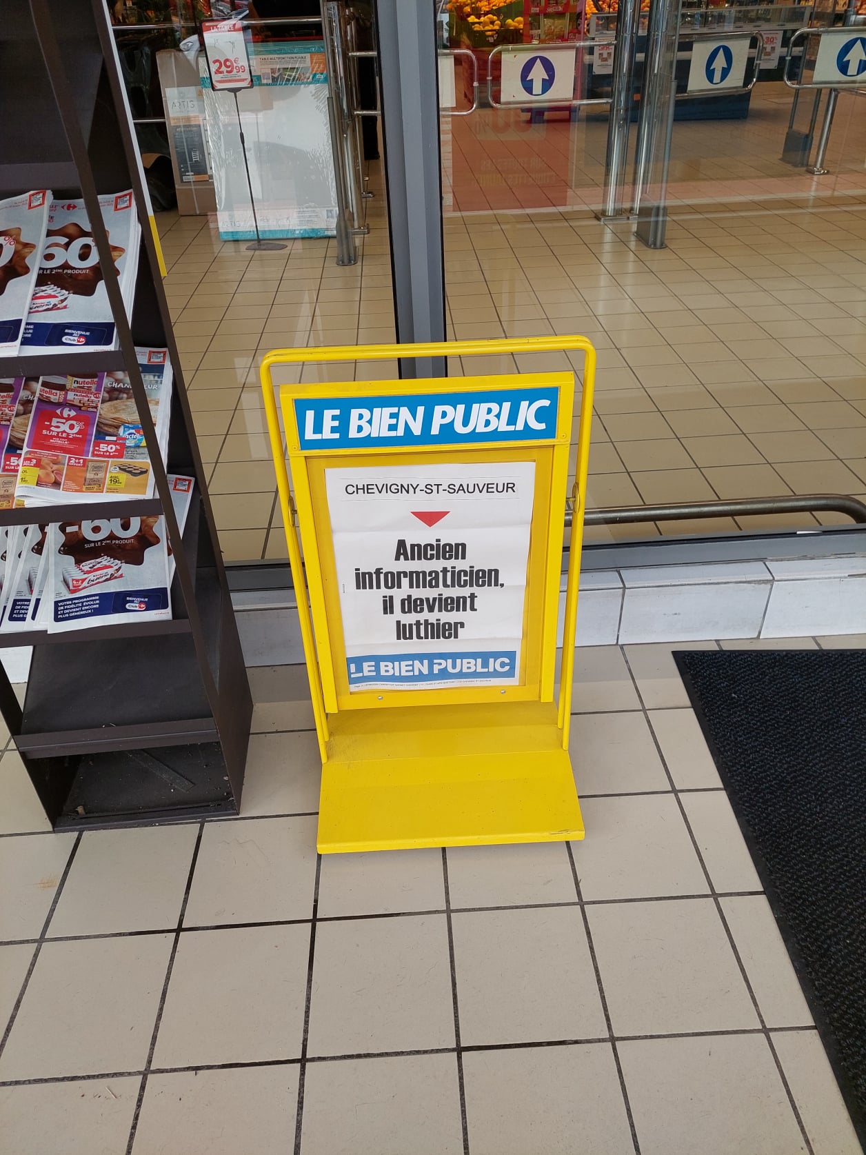 Panneau publicitaire pour un article dans le journal le Bien Public : Ancien informaticien, il devient luthier